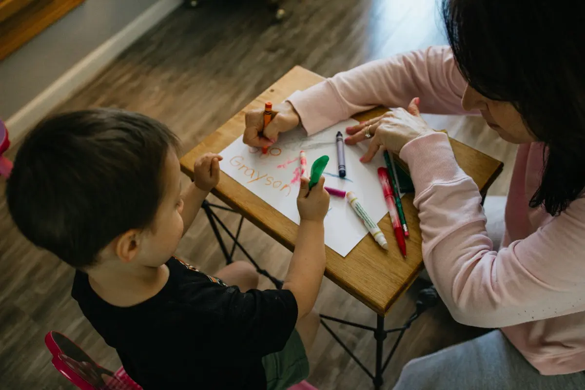 Two children playing with crayons