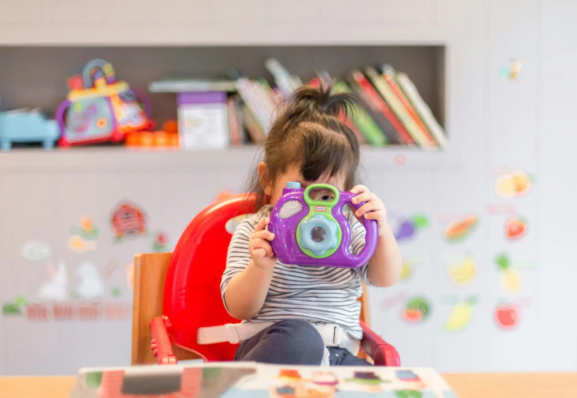 A child holding a toy camera